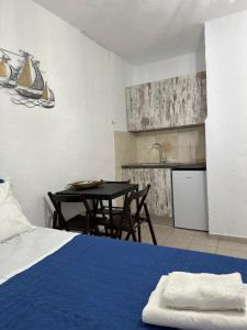 a bedroom with a bed and a table and a kitchen at Giannis in Pisses +30 photos