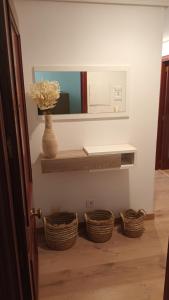 Un baño con dos cestas y un jarrón con flores. en Apartamentos Vino y Camino, en Nájera 14 fotos más