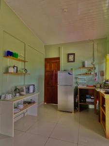 a kitchen with a refrigerator and a table in it at Casa mariposa in Uvita