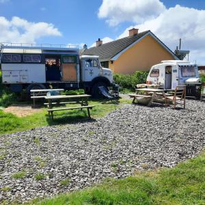 un paio di camion parcheggiati accanto a una casa di Ballincolla Base Camp a Ballinrolla