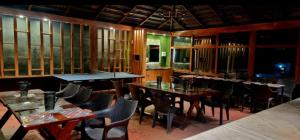 a dining room with tables and chairs and windows at Coffee Paradise Resort in Chikmagalūr