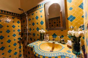 a bathroom with a sink, mirror, and bathtub at Riad Be Marrakech in Marrakesh