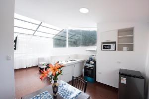 a kitchen with a vase of flowers on a table at Carmen's House in Cusco
