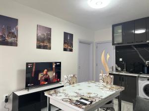 un soggiorno con tavolo e TV di Luxury Apartment in Centre of Stara Zagora a Stara Zagora