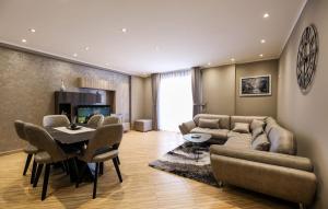a living room with a couch and a table and chairs at Valbona Apartament's 2 in Vlorë