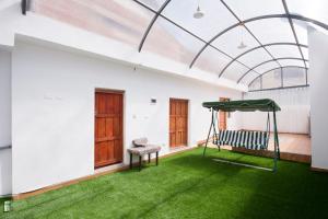 a room with a hammock and green grass at Carmen's House in Cusco