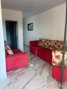 a living room with two red couches and marble floors at Departamento Puerto Esperanza in La Porteña