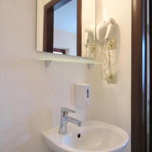 a bathroom sink with a mirror and a phone at Villa Kmeller in Lviv +52 photos