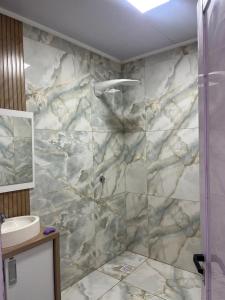 a bathroom with a marble shower with a sink at Departamento Puerto Esperanza in La Porteña