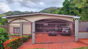 a garage with a red gate with two cars in it at Coconut Lodge in Panama City