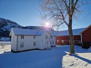 a white barn in the snow next to a red barn at Selnestun in Selnes
