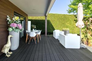drewniany taras ze stołem i parasolem w obiekcie Norte de Santillana Villas - Apartamentos w mieście Santillana del Mar