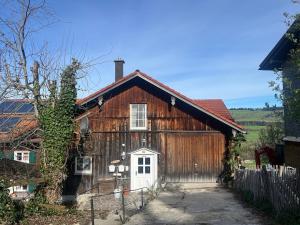 a large wooden barn with a white door at Schads Bergheimat in Wertach
