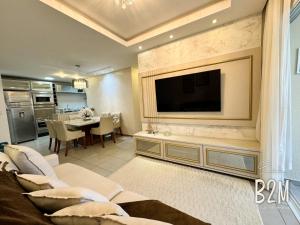 Una sala de estar con un televisor en la pared. en Requinte e sofisticação a beira-mar, Beto Carrero, en Penha