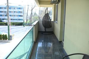 a balcony with a view of a swimming pool and a chair at Evo Moonlight by the sea in Mamaia