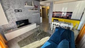 a living room with a blue couch and a kitchen at Evo Moonlight by the sea in Mamaia