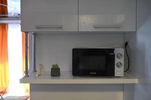 a microwave sitting on a counter in a kitchen at Evo Moonlight by the sea in Mamaia