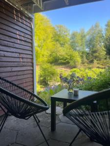 a table and a chair on a patio with a view of a garden at Hygge i det grønne in Langå