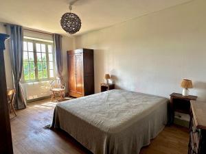 a bedroom with a bed and a large window at Vézelay, Maison de Marita in Vézelay