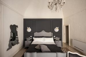 una camera da letto con un letto grande e un lampadario di Bianko EcoChic a Enna