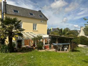 una casa con patio e tavolo nel cortile di Maison familiale à Morgat, jardin clos, à 2 minutes de la plage a Crozon