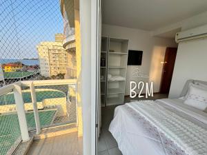 Un dormitorio con una cama y un balcón con vistas. en Requinte e sofisticação a beira-mar, Beto Carrero, en Penha 62 fotos más