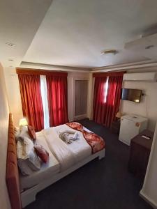 1 dormitorio con 1 cama grande y cortinas rojas en Cairo Heart Hotel By GH For Hotels, en El Cairo