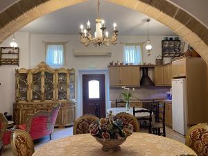 eine Küche und ein Esszimmer mit einem Tisch und einem Kronleuchter in der Unterkunft Kamara Cottage - Traditional Stone House in Malona Village