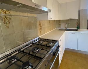 een keuken met een kookplaat en witte kasten bij MIRA IL MARE Seaview Apartment - Sunset Lovers' Spot - 50m from the Beach LAVINIO MARE in Anzio