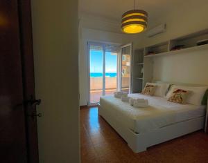 een slaapkamer met een bed met uitzicht op de oceaan bij MIRA IL MARE Seaview Apartment - Sunset Lovers' Spot - 50m from the Beach LAVINIO MARE in Anzio