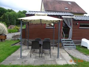 a table and chairs under an umbrella on a patio at Tiny-house in Wihr-au-Val +10 photos