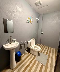 a bathroom with a toilet and a sink at Shanti's Inn in General Luna