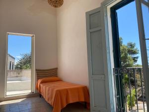 a room with an open door to a balcony with an orange blanket at Villa Mozia riserva dello Stagnone in Marsala