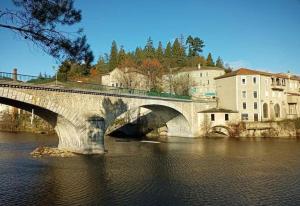 a stone bridge over a river in a city at Gîte Lydmalida cocon Ardéchois in Les Ollières-sur-Eyrieux