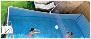 two women playing with a ball in a swimming pool at Paraiso Suit Casas Lacambra in Tolosa