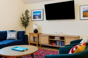 a living room with two blue couches and a tv at Mountain Mojo Luxe Cabin Vibes in McGaheysville +28 photos