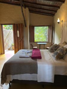 un grand lit dans une chambre avec une fenêtre dans l'établissement Ecocentro Brasil - Bangalô 2, à São Pedro