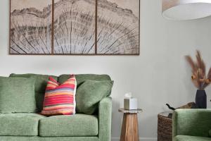 a living room with a green couch with a striped pillow at The Songbird 99 in Redding +59 photos