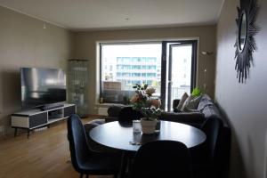 a living room with a couch and a table with chairs at Staymate apartment at Lade in Trondheim
