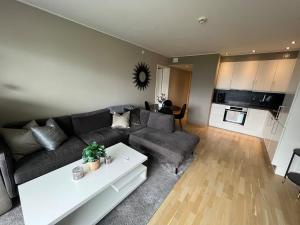 a living room with a couch and a table at Staymate apartment at Lade in Trondheim