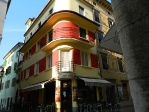 a yellow and red building on a city street at Vecchia Riva in Riva del Garda