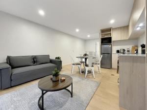 a living room with a couch and a table at Spacious Allen Street 1BR Stay in Christchurch +3 photos