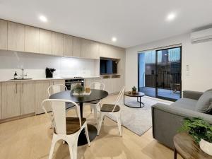 a kitchen and living room with a table and chairs at Spacious Allen Street 1BR Stay in Christchurch