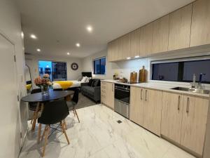 a kitchen with a table and a living room at Stylish and Lush CBD Studio in Christchurch