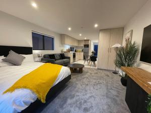 a bedroom with a large bed and a living room at Stylish and Lush CBD Studio in Christchurch