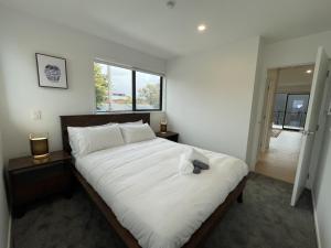 a bedroom with a large white bed and a window at Relaxing CBD Getaway in Christchurch