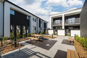 a patio with a wooden bench and a building at Relaxing CBD Getaway in Christchurch