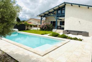 a swimming pool in front of a house at Villa Spa du Bassin - Le Teich - Bassin d'Arcachon in Le Teich