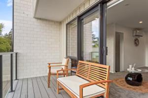 une terrasse avec deux chaises et une table dans l'établissement Well-styled Vibrant 2 Bed Home, à Auckland