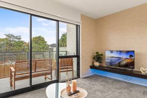 un salon avec une grande fenêtre et une télévision dans l'établissement Well-styled Vibrant 2 Bed Home, à Auckland